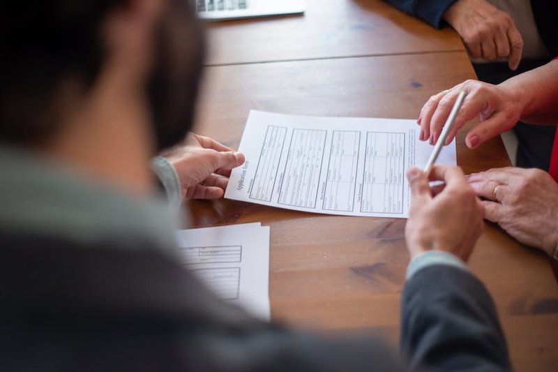 Singapore business owner reviewing a PSG grant application document with a marketing agency representative